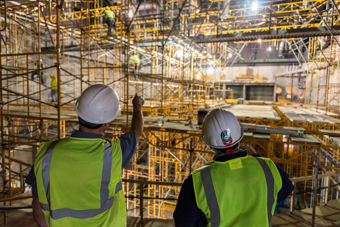 Two Electricians looking at a scaffolding