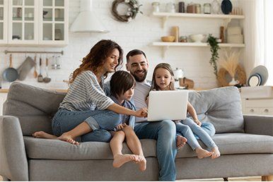 Happy Family With Kids Sit on Couch — White Bear Lake, MN — Reibel Heating & Air Conditioning Happy Family With Kids Sit on Couch — White Bear Lake, MN — Reibel Heating & Air Conditioning