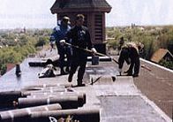 Contractor Installing Bitumen Roof System - Hot Tar Roof Installation in Swansboro, North Carolina Contractor Installing Bitumen Roof System - Hot Tar Roof Installation in Swansboro, North Carolina