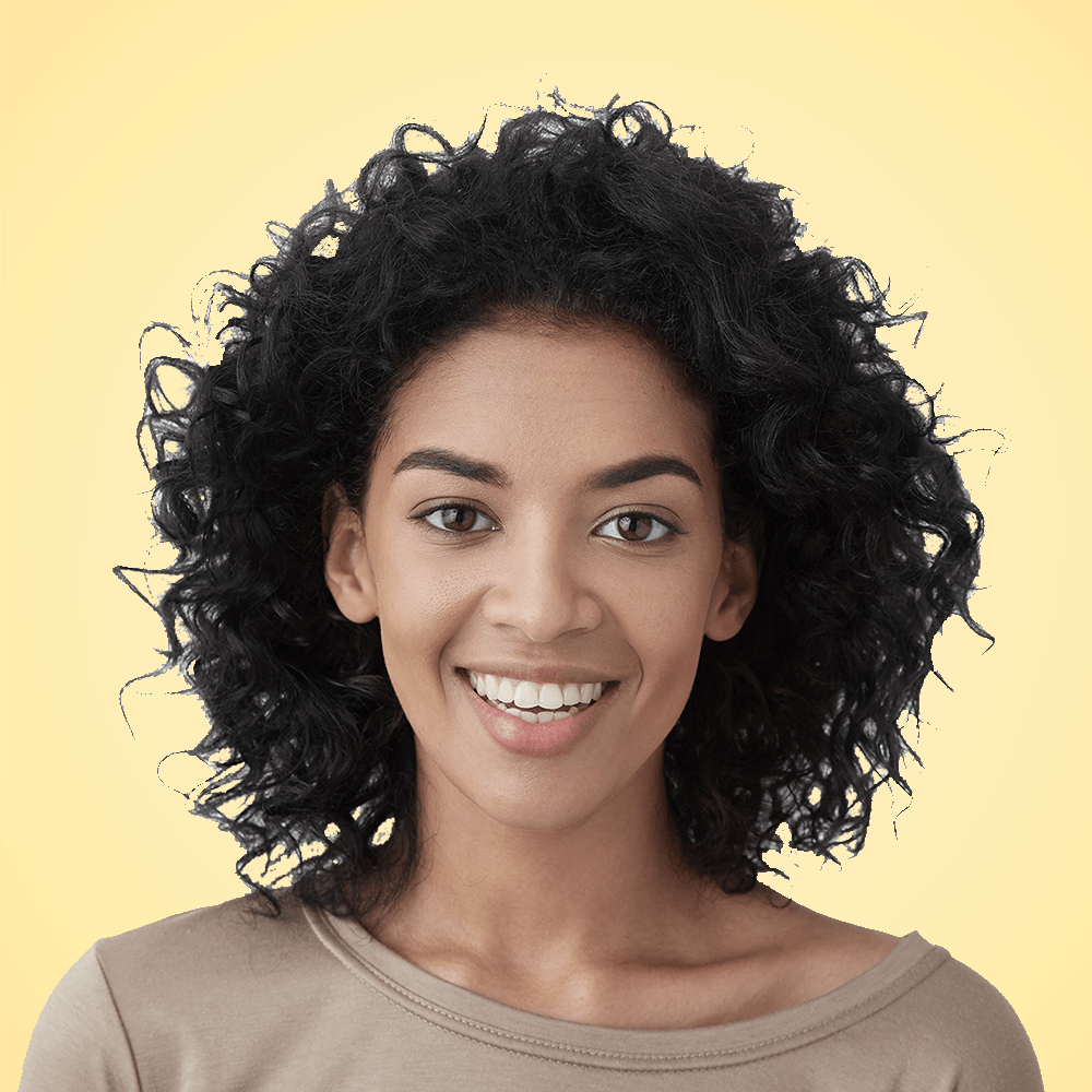 Woman with curly black hair smiles broadly.