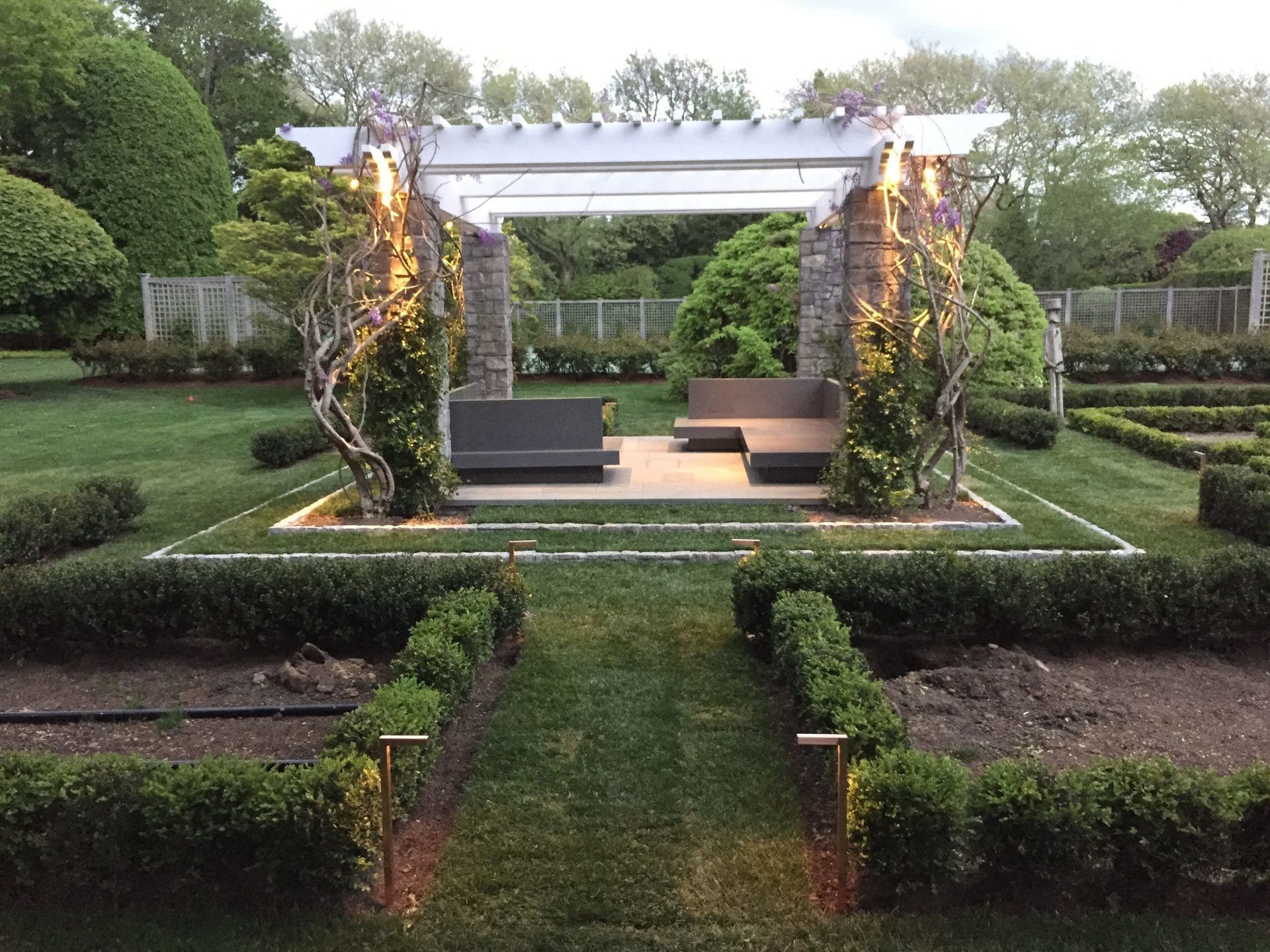 A pergola in the middle of a lush green garden