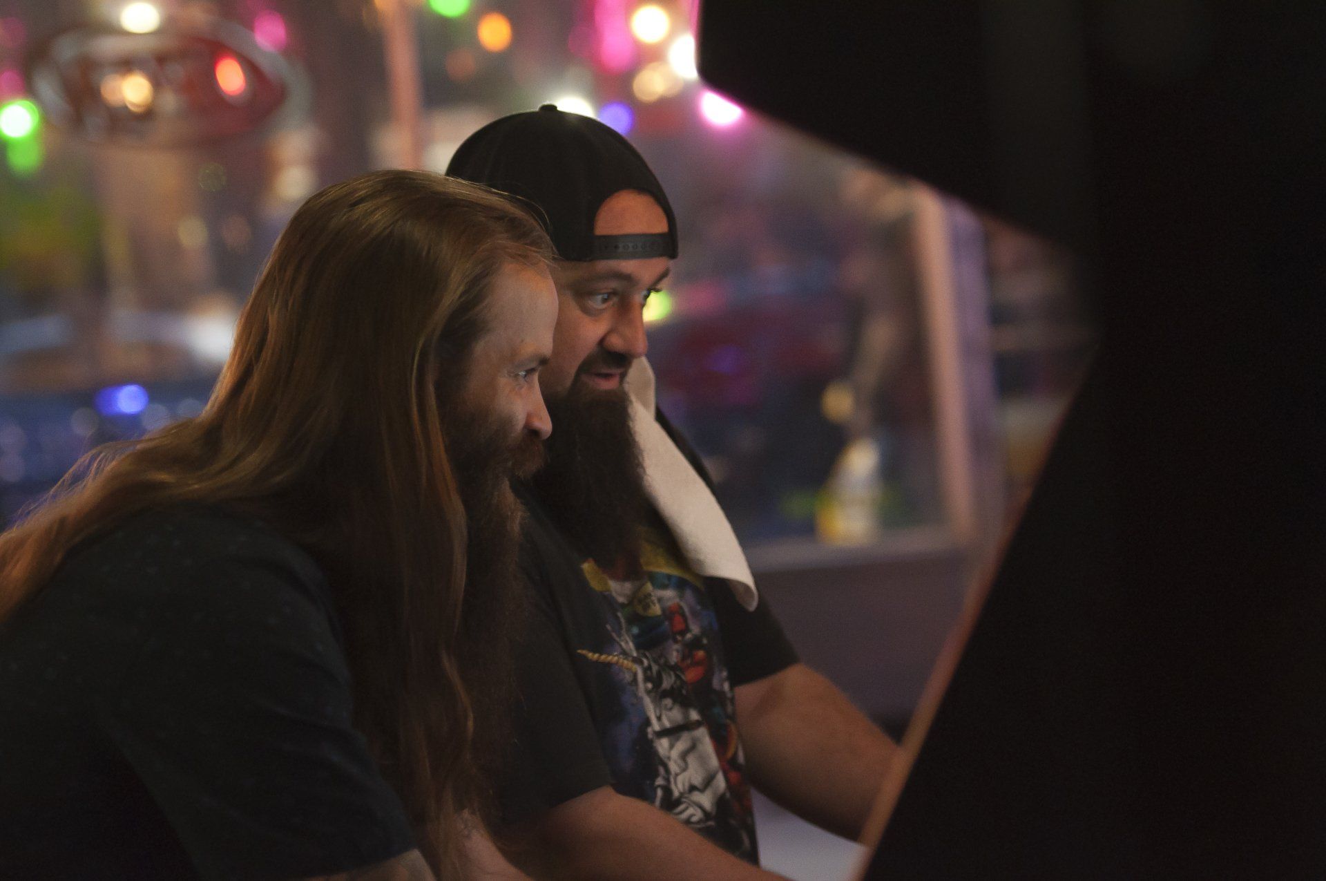 Two men play an arcade game