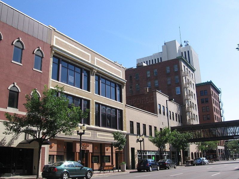 a row of buildings with a green car parked in front