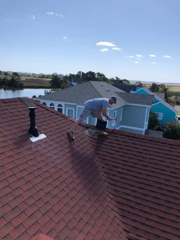 a man working on the roof of a house