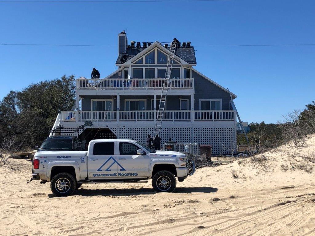 a white truck is parked in front of a large house .