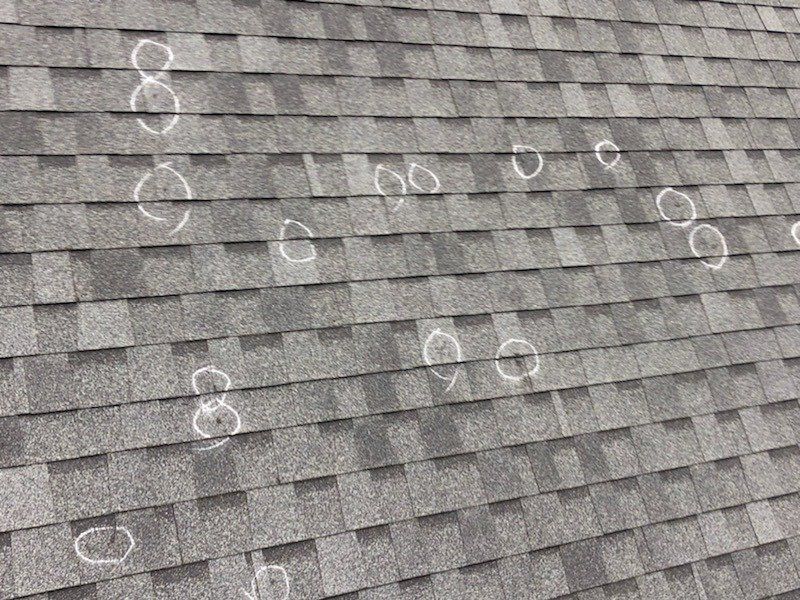 a close up of a roof with hail damage on it .