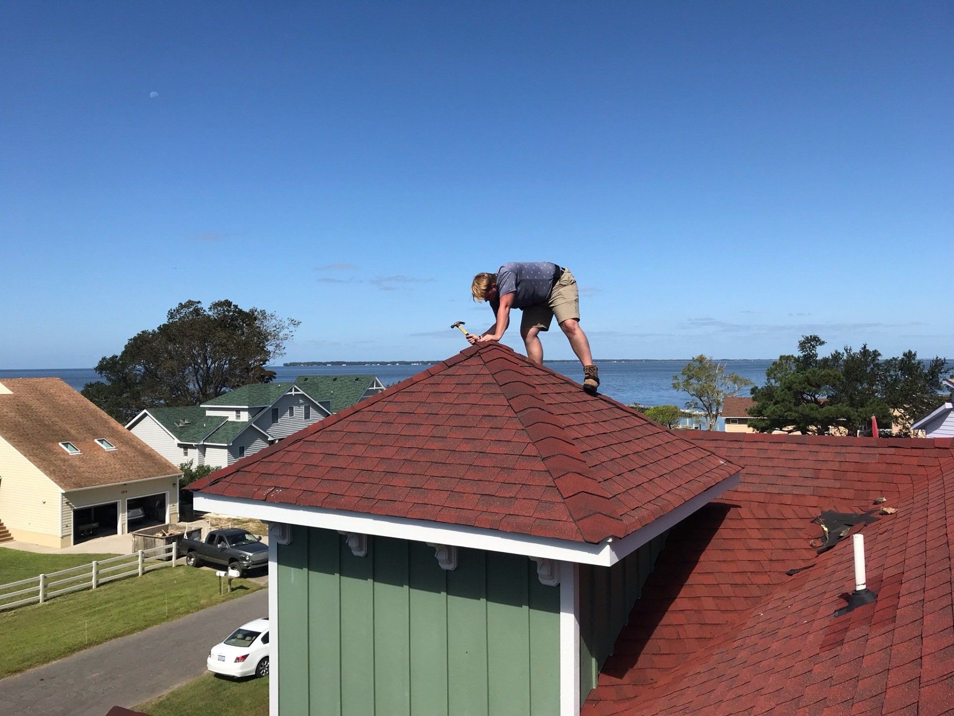a man working on the roof of a house .