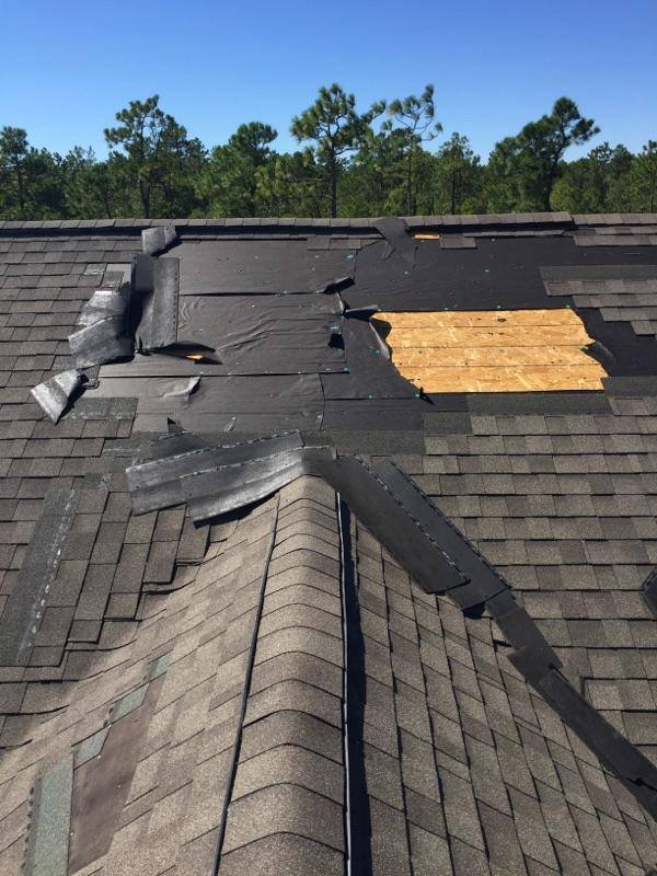 a roof with shingles missing and a hole in it .