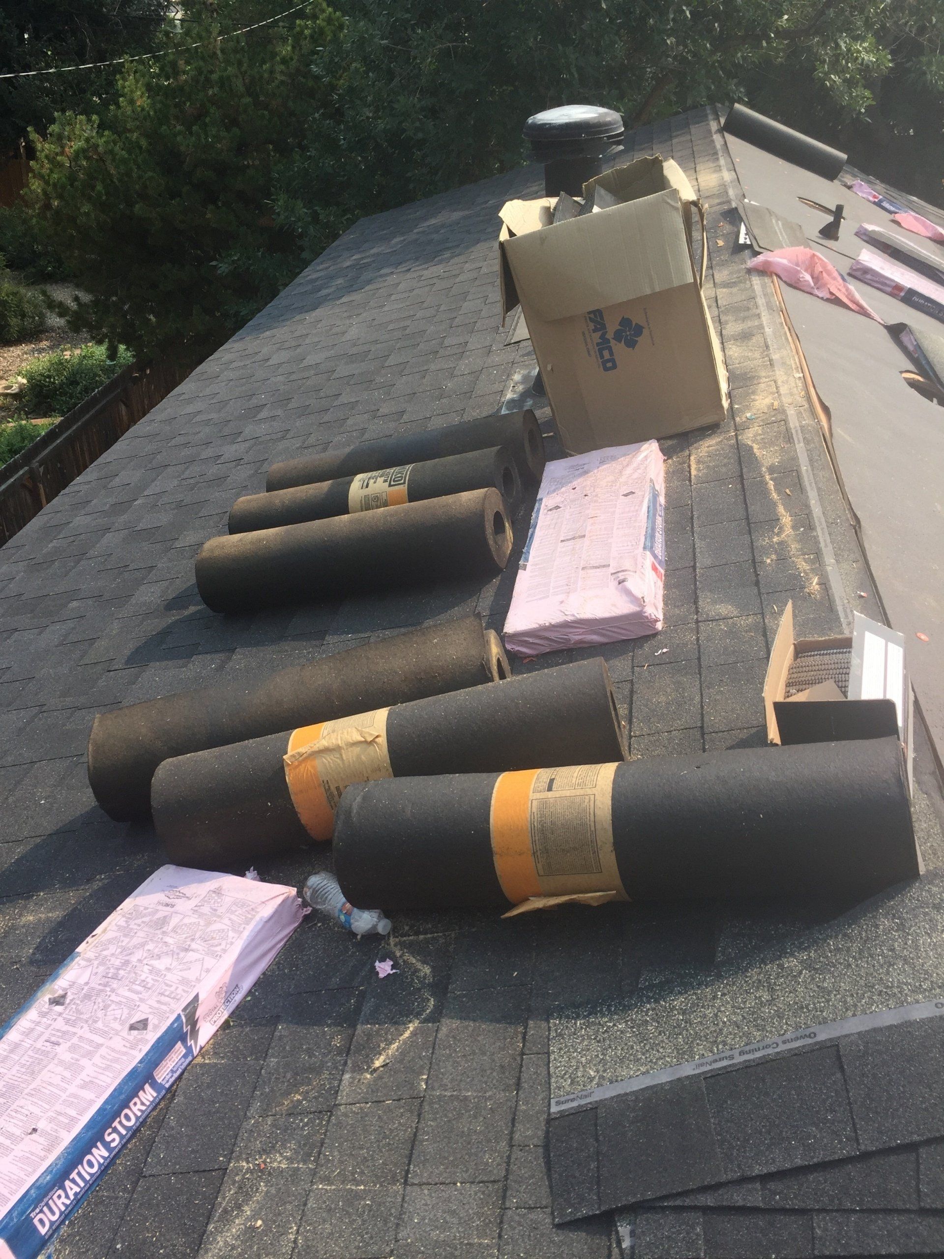a roof with rolls of shingles and foam on it .