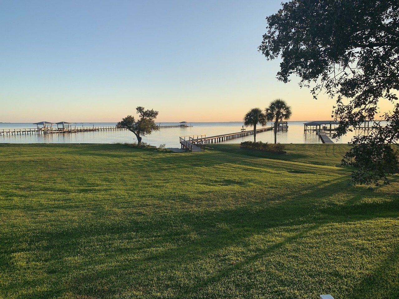 a grassy field with a view of a body of water