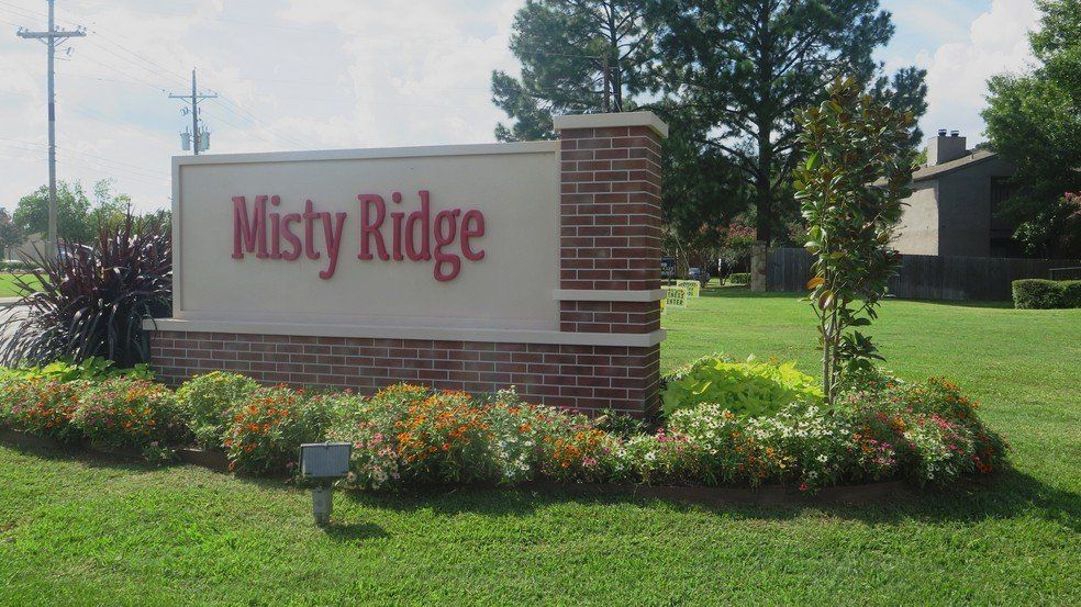 Misty Ridge sign with brick accents, surrounded by landscaping, set on a green lawn.