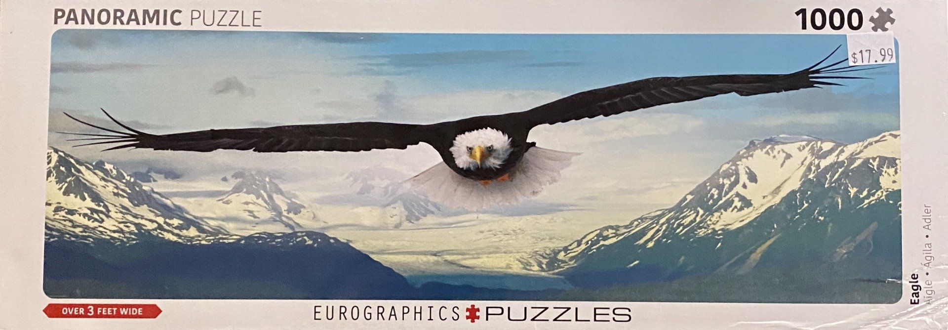 A panoramic 1000-piece jigsaw puzzle box showing a bald eagle flying over a snow-capped mountain range.