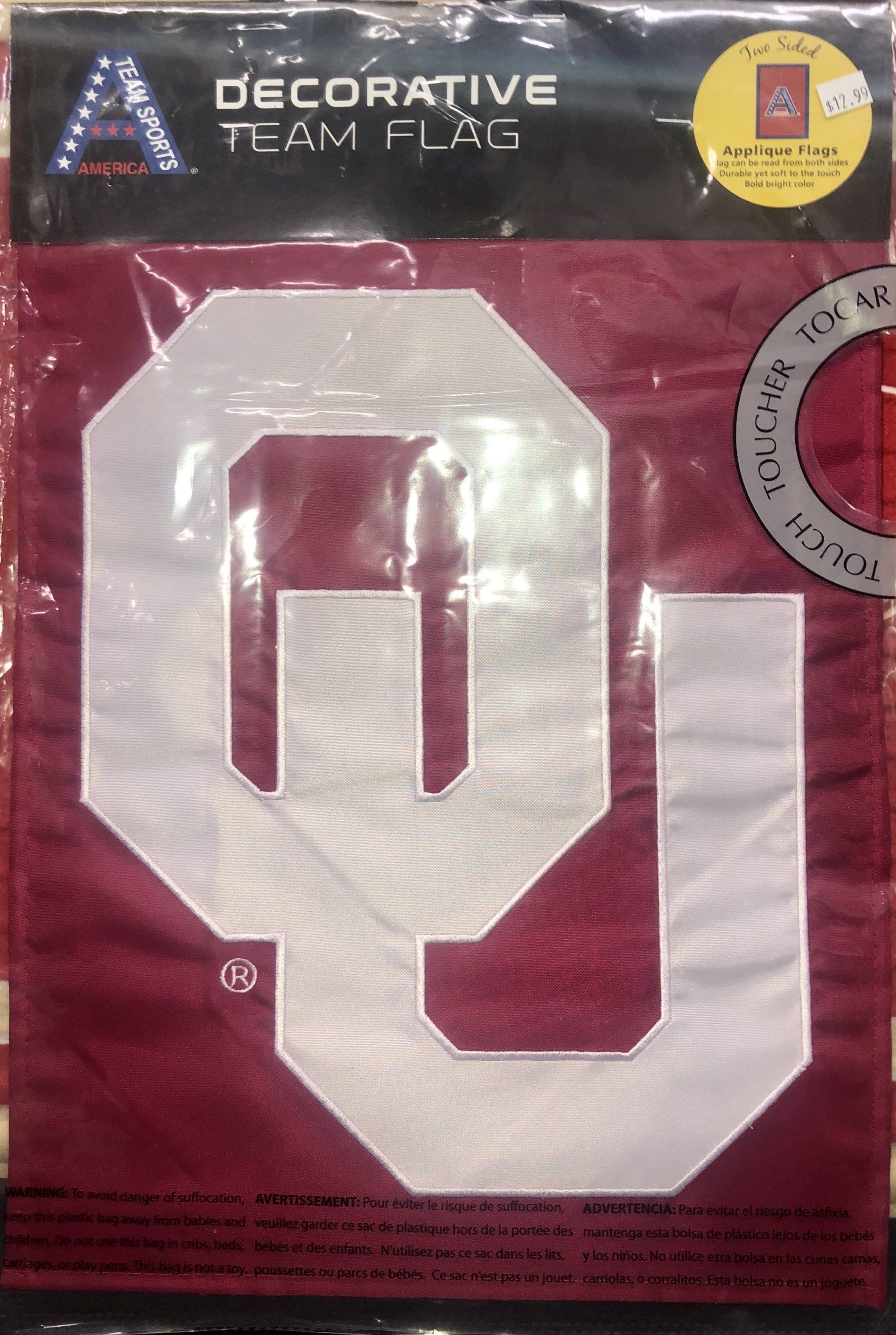 A burgundy and cream Oklahoma Sooners decorative team flag in its original plastic packaging.