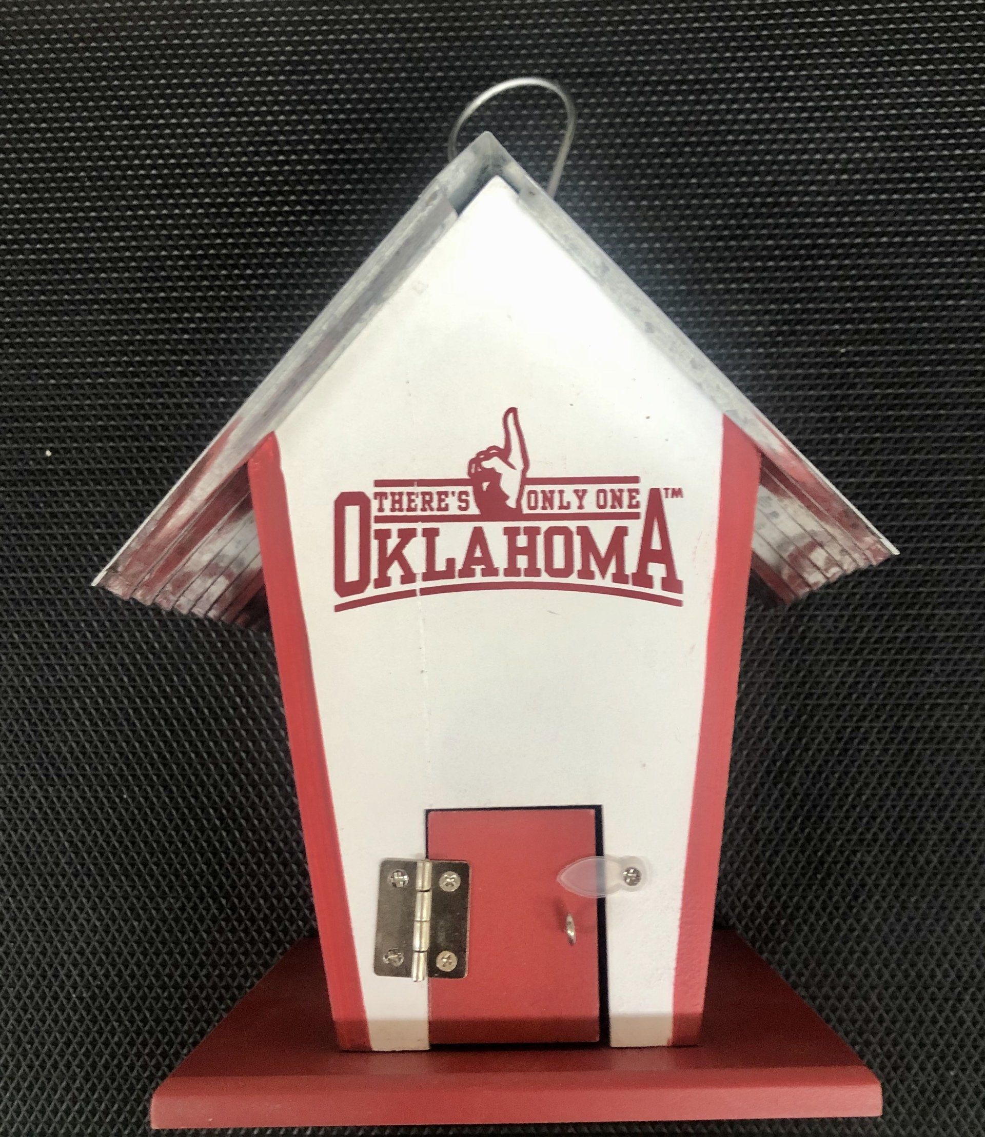 A white and red wooden birdhouse featuring the 