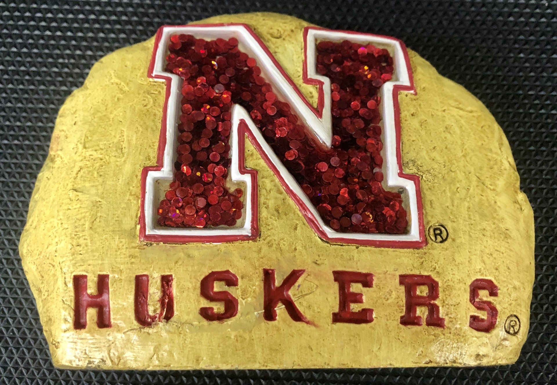 A gold stone-textured plaque featuring the Nebraska 