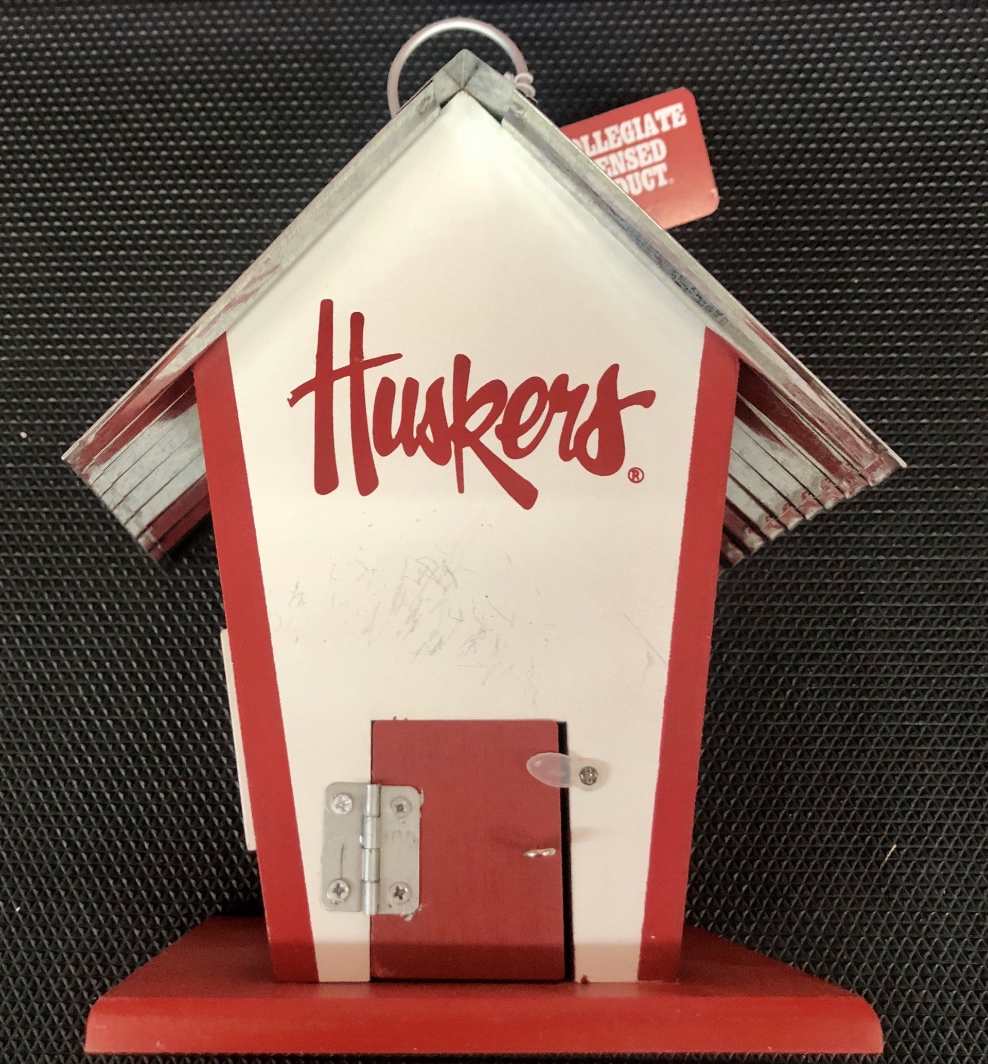 A red and white rustic wooden birdhouse with a 