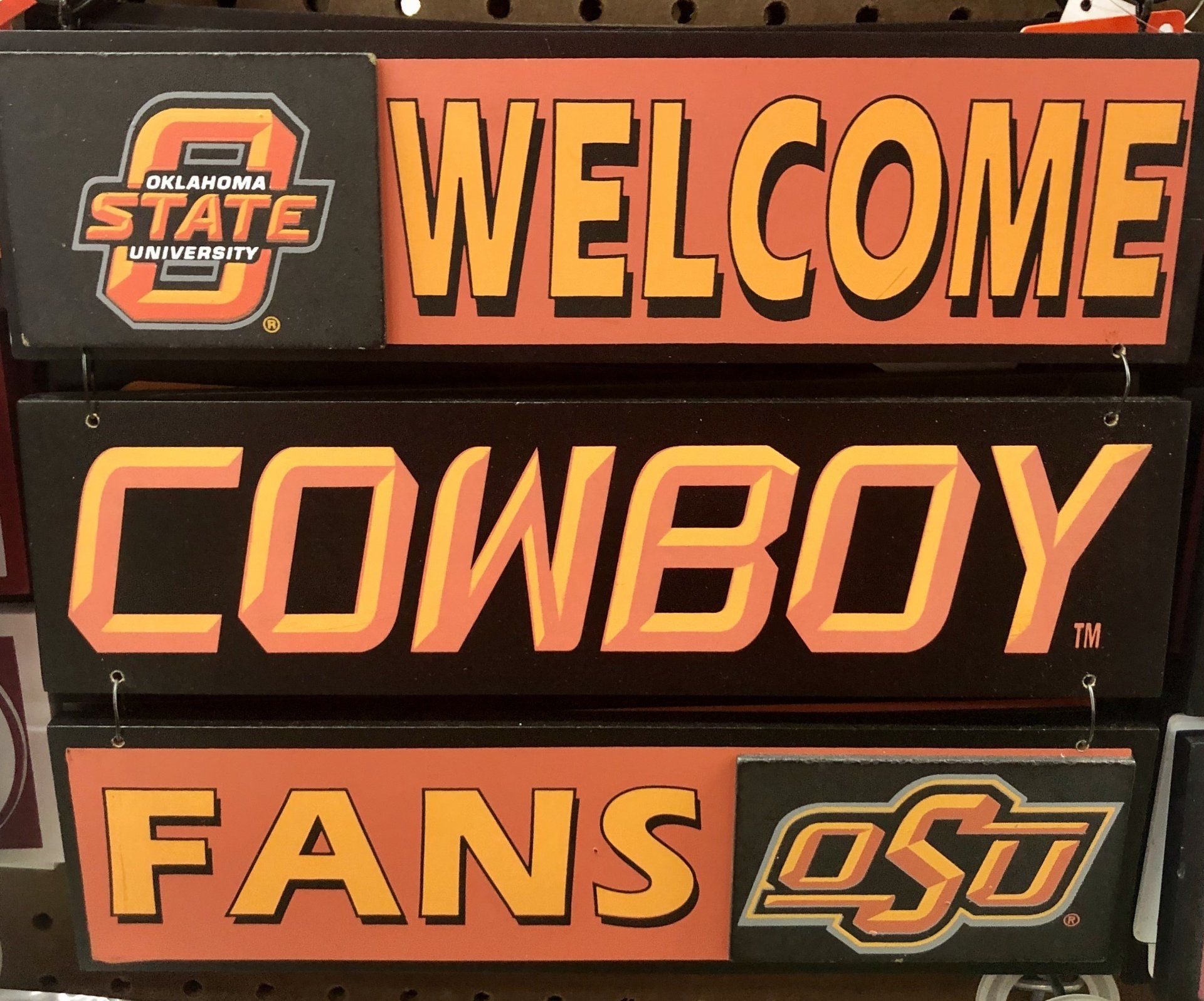 Three stacked Oklahoma State University signs reading 