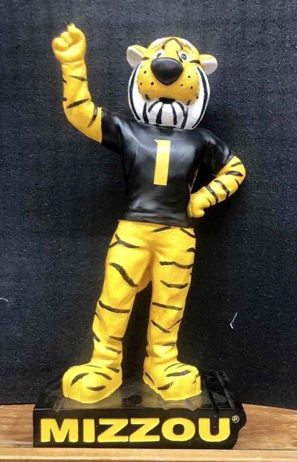 A Mizzou tiger mascot statue wearing a black jersey with the number 1, standing on a black base labeled 