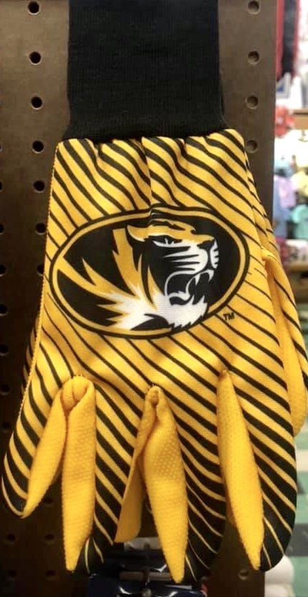 A yellow and black striped work glove with the University of Missouri tiger logo, hanging on a display wall.