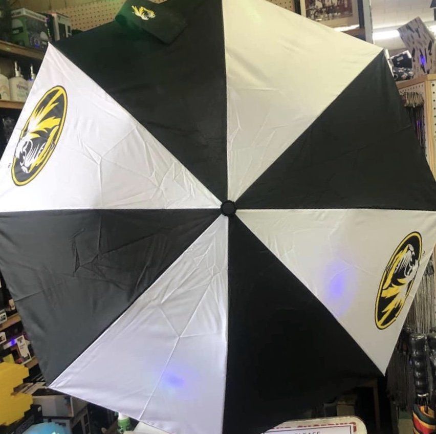 An umbrella with alternating black and white panels, featuring the University of Missouri Tigers logo on white panels.