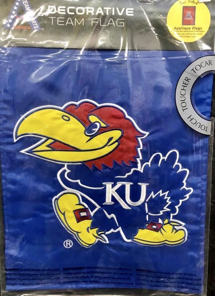A blue Kansas Jayhawk decorative team flag in clear plastic packaging.