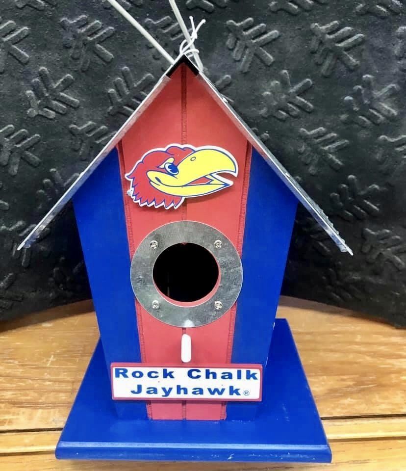 A birdhouse painted in Kansas Jayhawks red and blue with the team mascot logo and 