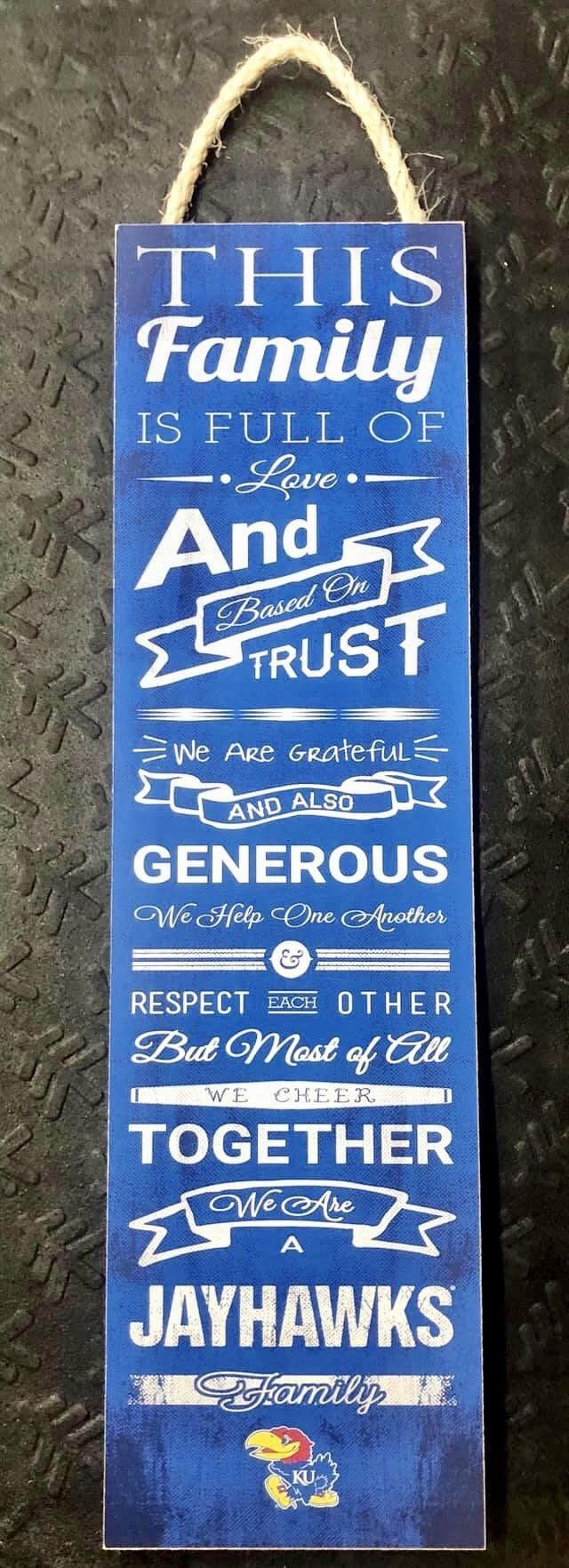A blue decorative wall sign featuring text about family values and the Kansas Jayhawks mascot at the bottom.
