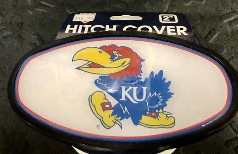 A University of Kansas Jayhawk oval trailer hitch cover on its retail packaging.