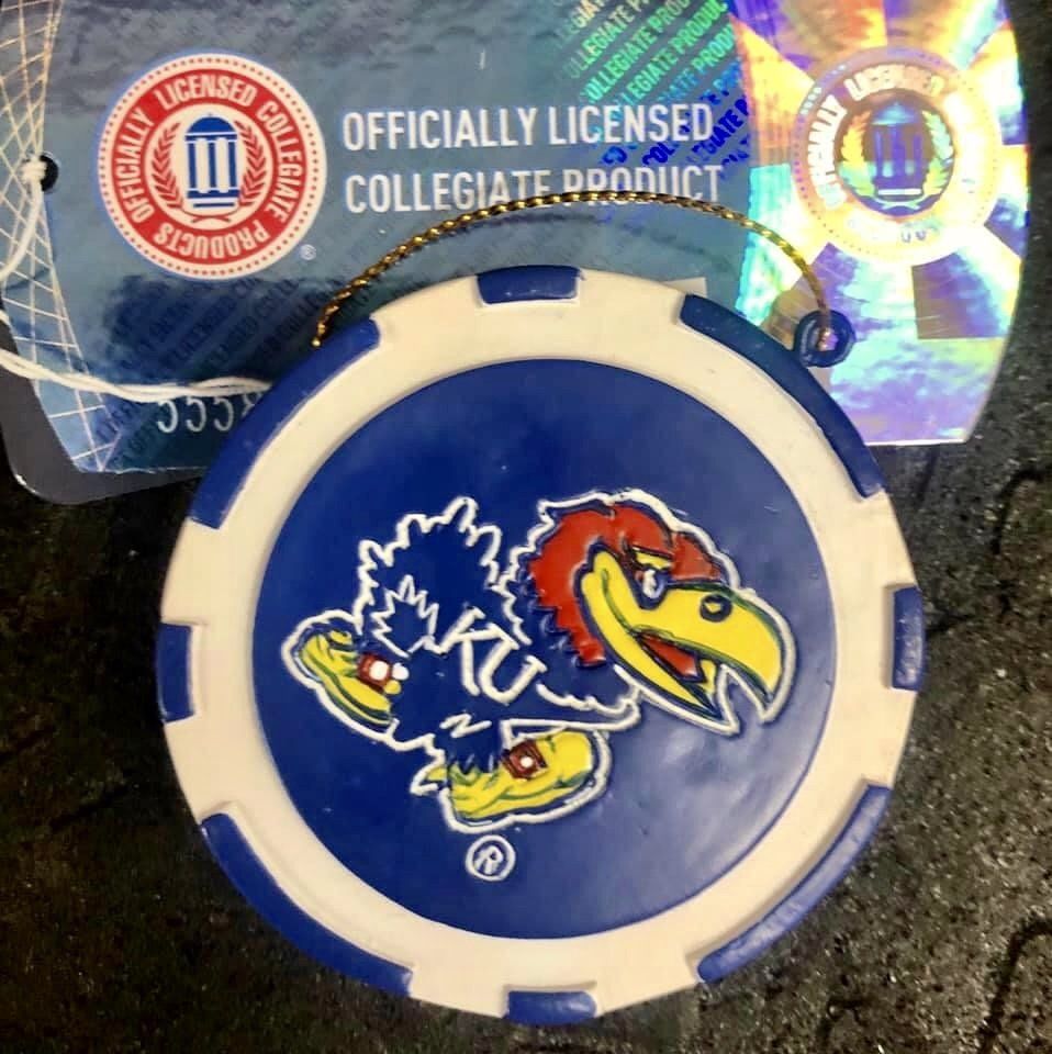 A Kansas Jayhawks logo on a round blue and white poker chip with a string, with an 