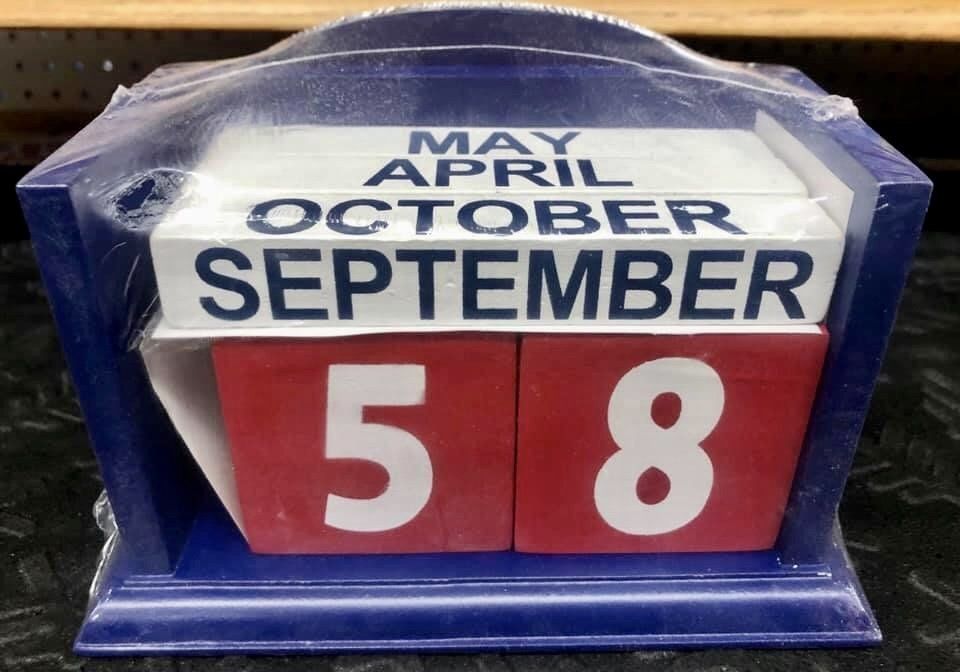 A blue wooden perpetual calendar block set displays 