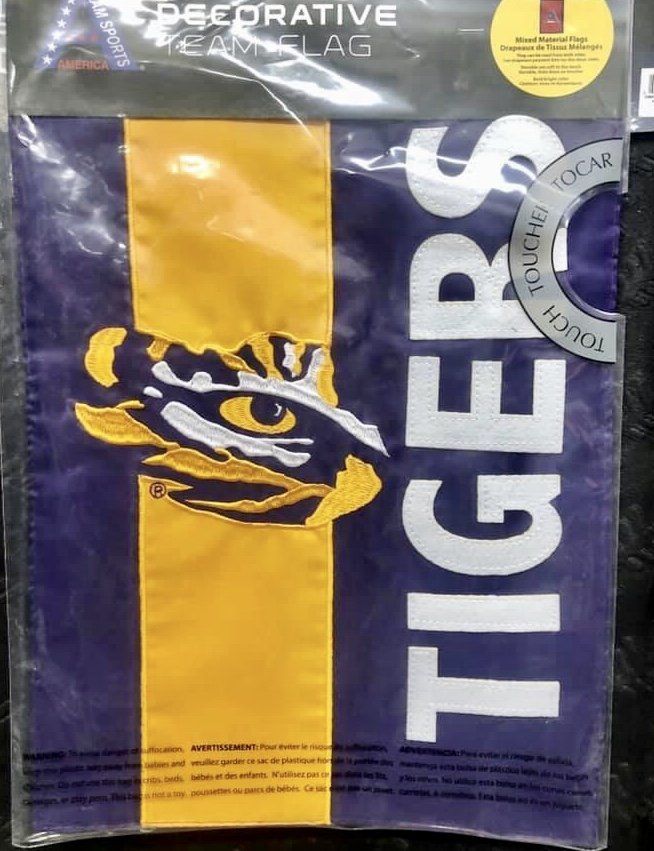 A purple and gold LSU Tigers decorative garden flag in clear packaging featuring a tiger eye logo and the word TIGERS.
