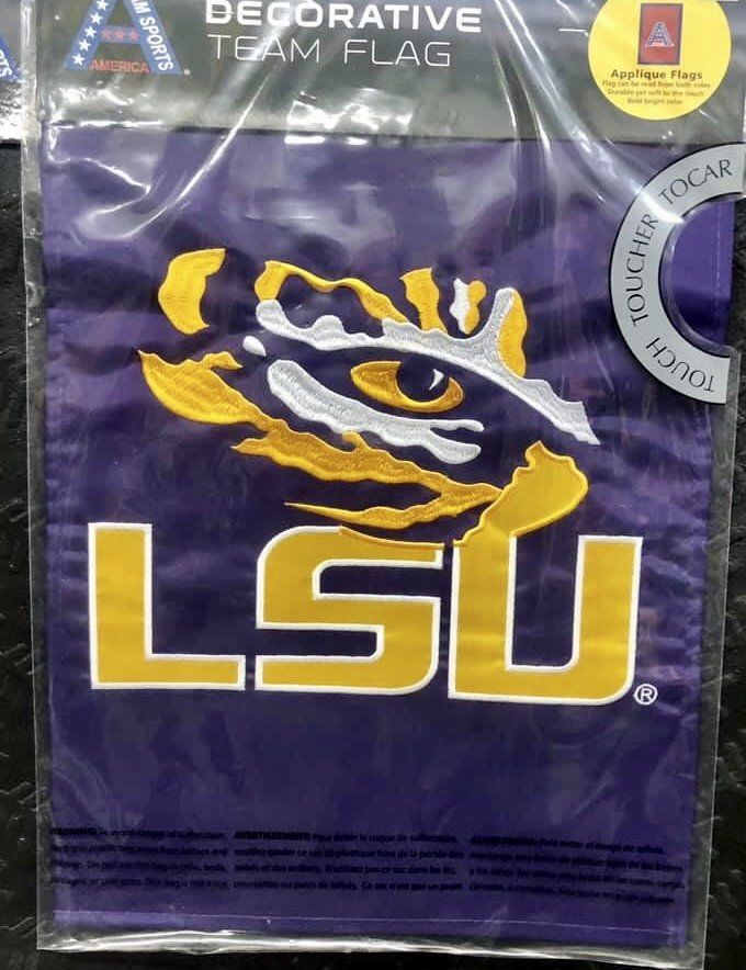 A purple LSU decorative team flag featuring the gold and white tiger eye logo and LSU lettering in a plastic package.