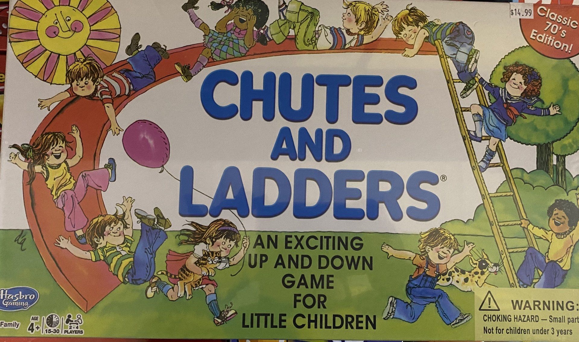 The board game box for Chutes and Ladders features children playing on a slide and ladder against a sunny, outdoor backdrop.