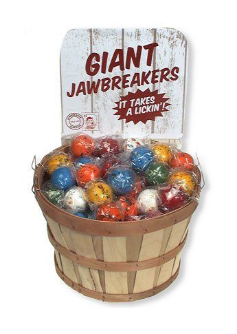 A wooden basket filled with individually wrapped, colorful giant jawbreakers, topped with a branded display sign.