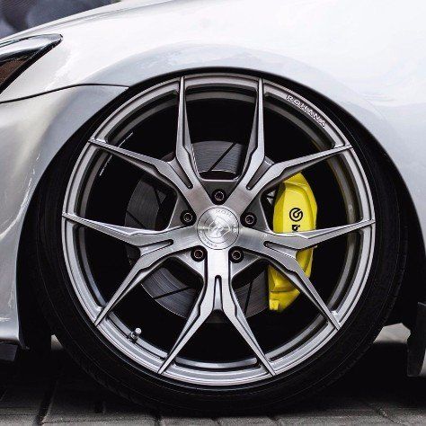 A close up of a car wheel with a yellow brembo brake