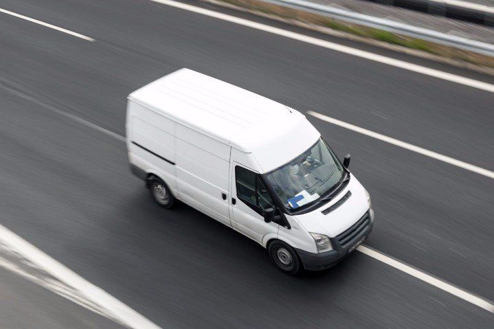 A white van is driving down a highway.