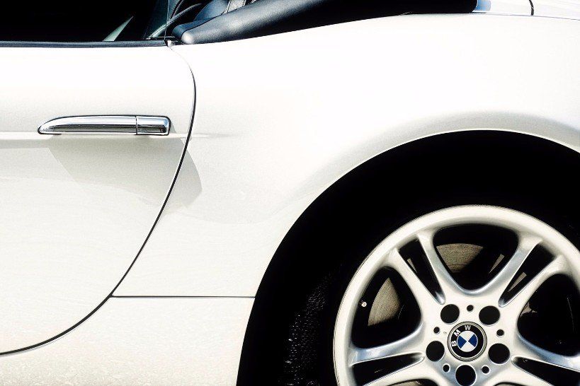 A white car with a bmw logo on the wheel