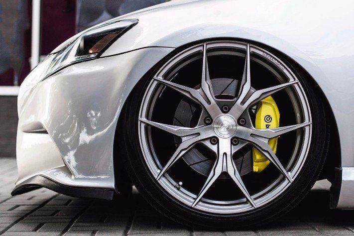 A close up of a car wheel with yellow brake calipers.