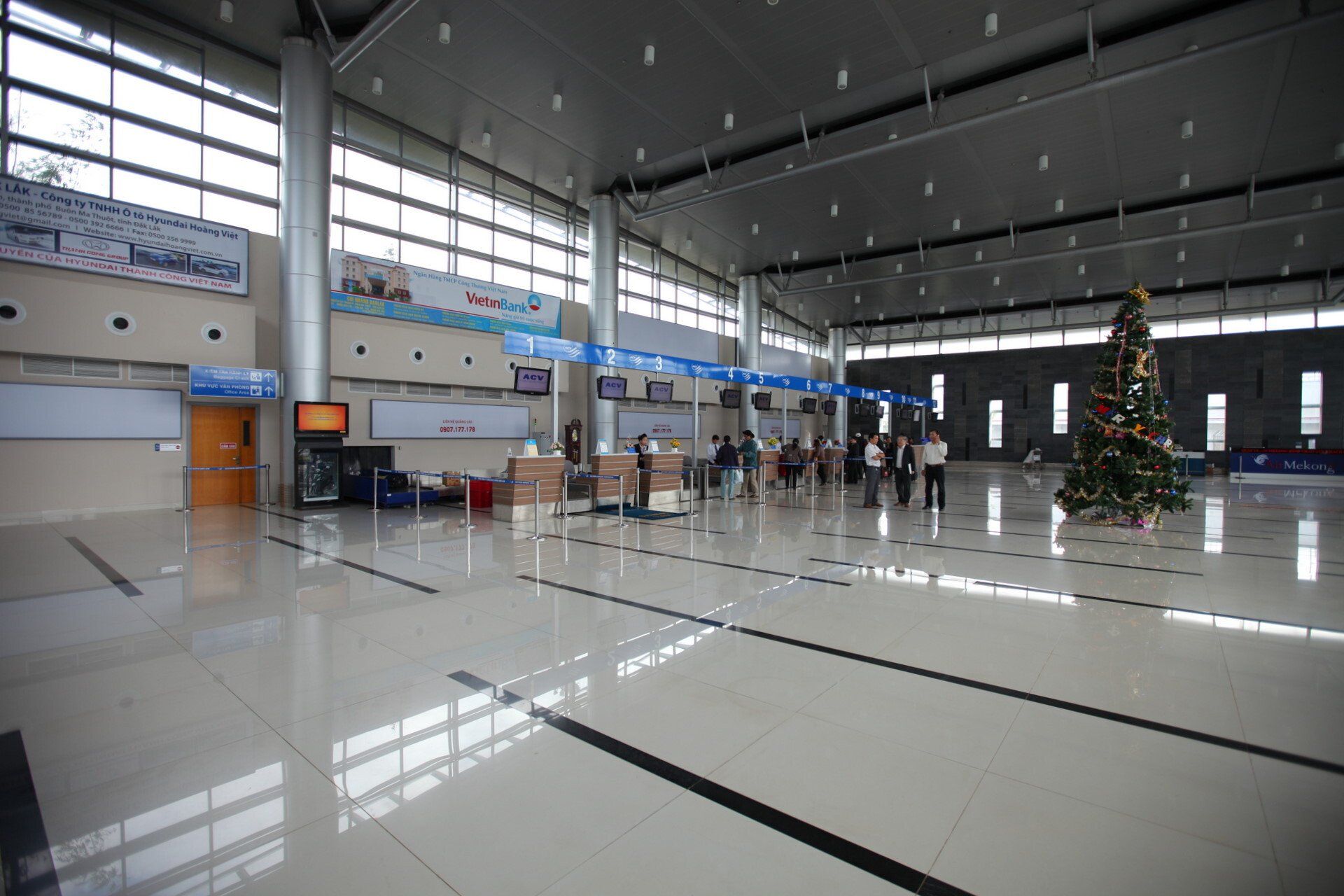 A large empty airport with a christmas tree in the middle