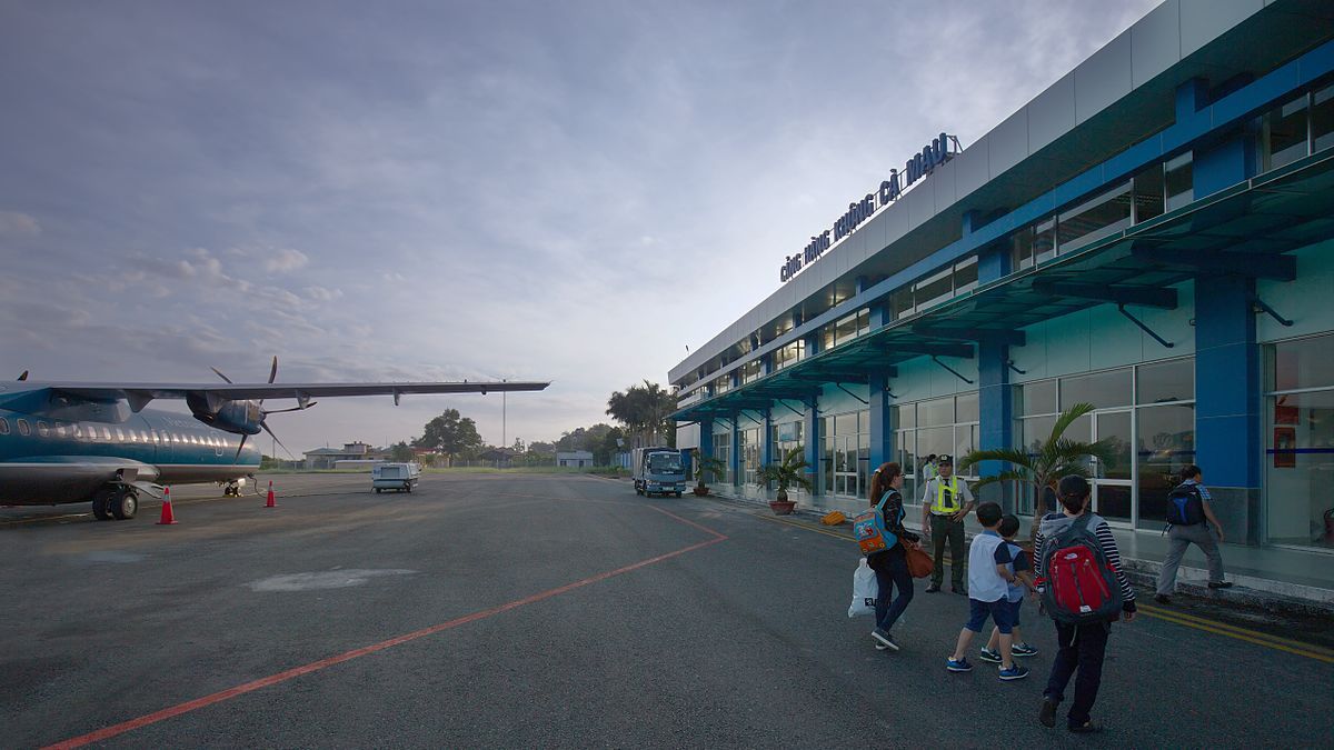 A group of people are walking towards a plane at an airport.