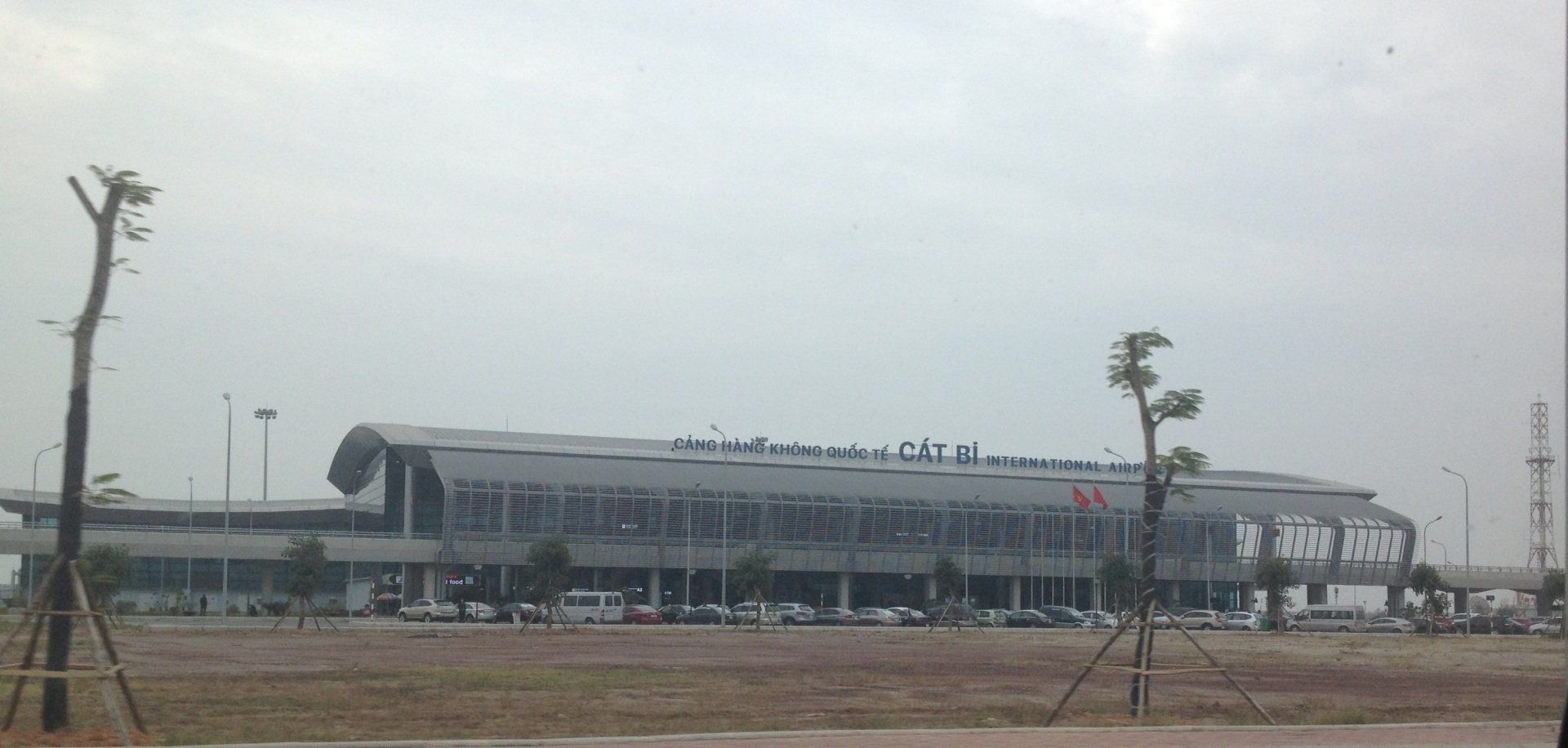 A large building with a lot of windows is sitting in the middle of a field.