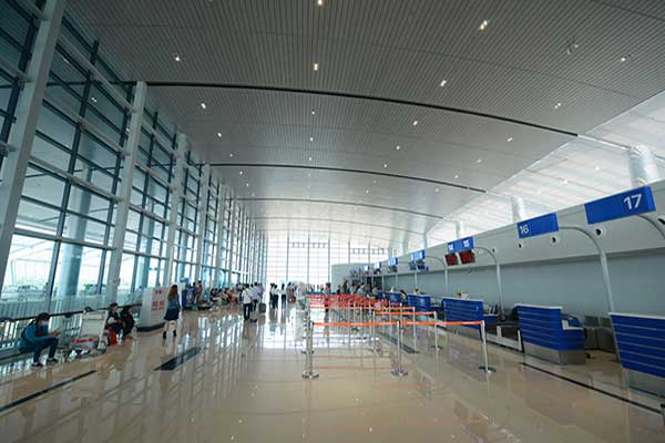 A large empty airport terminal with a lot of windows.