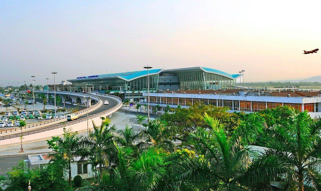An aerial view of an airport with a plane flying overhead.