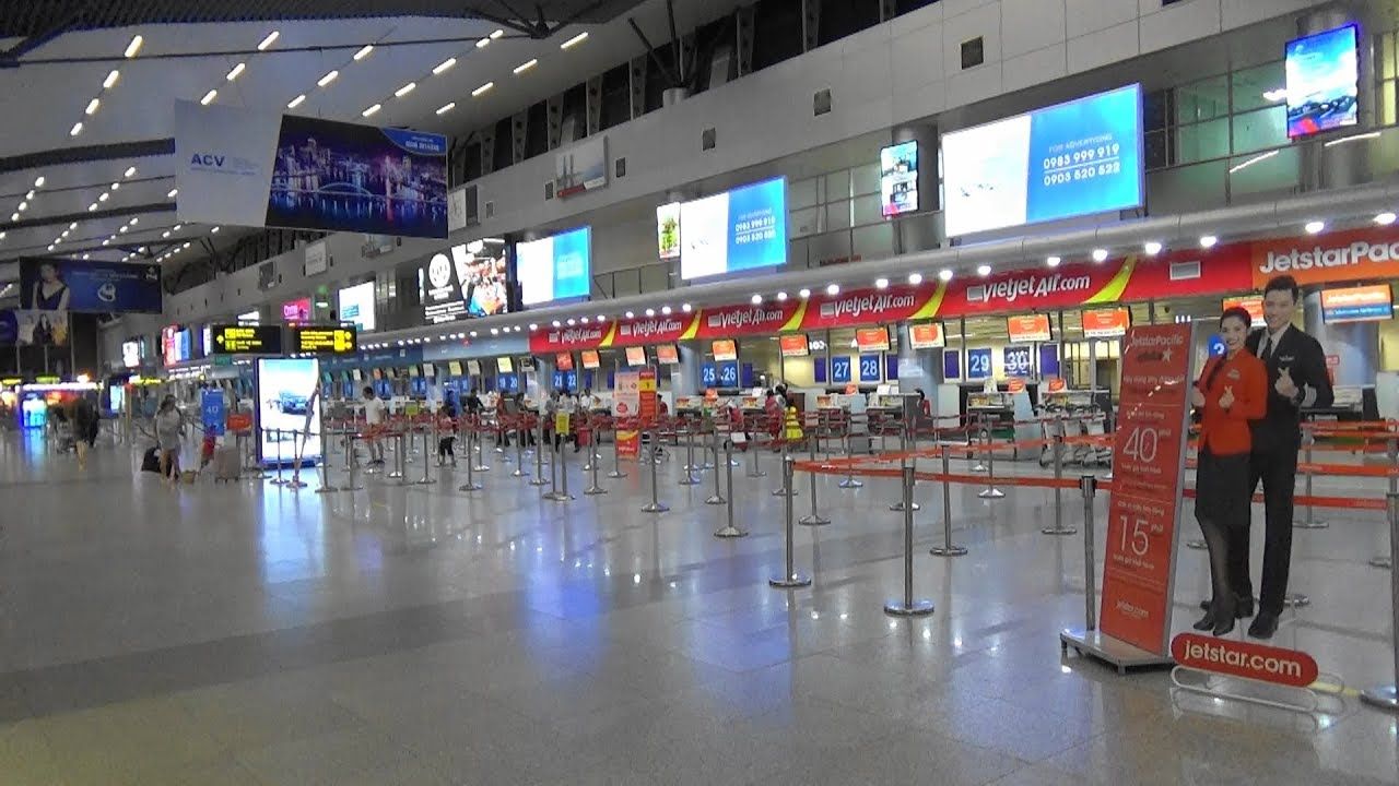 A couple of people standing in an airport waiting area.