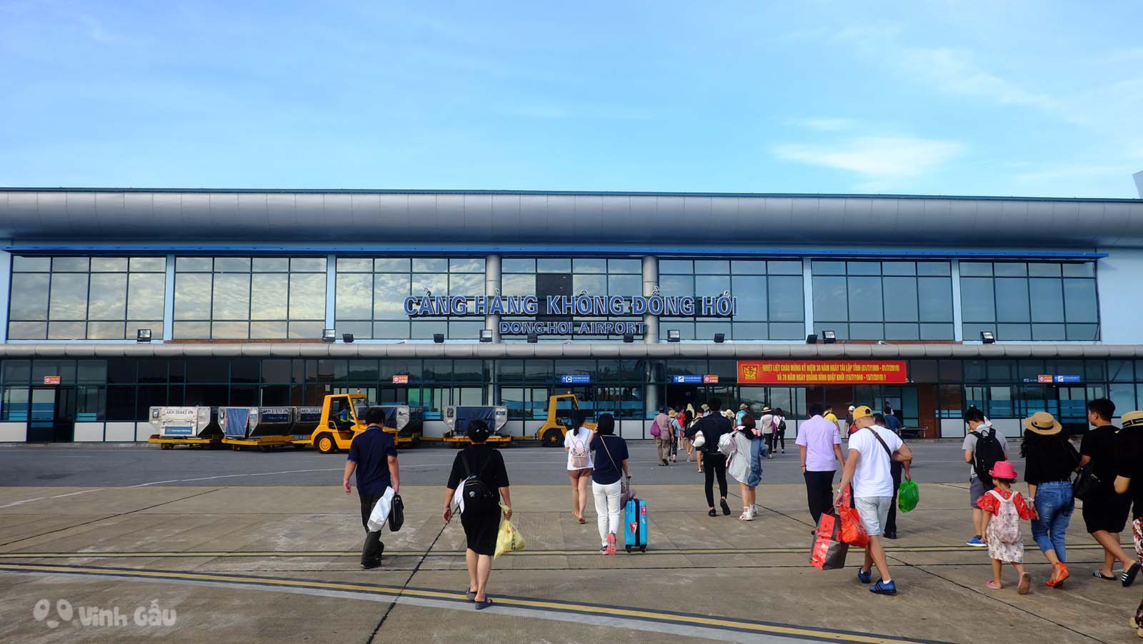A group of people are walking in front of a large building.
