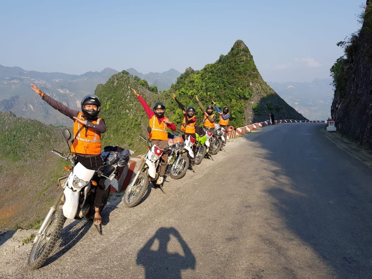 A group of people are riding motorcycles down a mountain road.