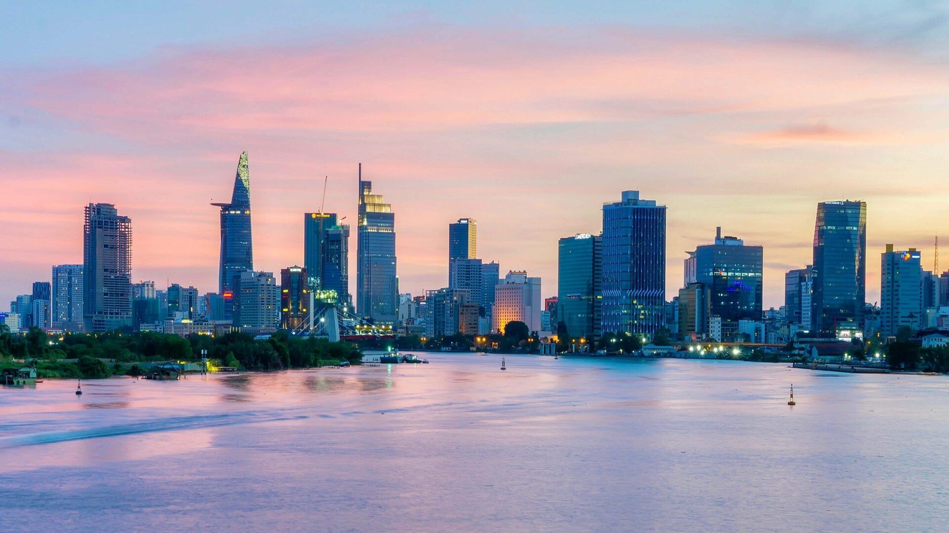 A city skyline over a body of water at sunset.