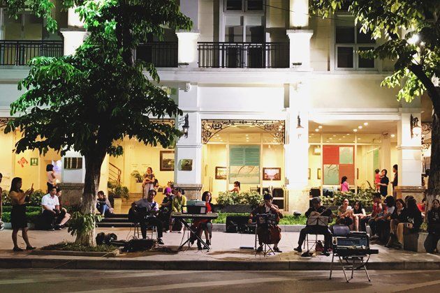 A group of people are sitting at tables outside of a building.