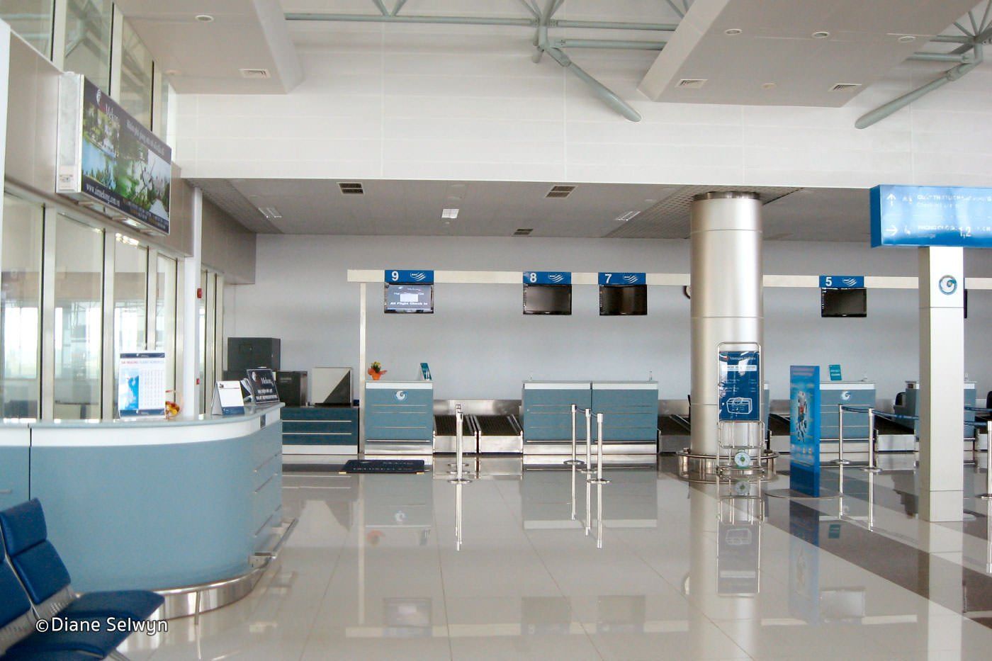 An empty airport with a blue sign that says ' check in ' on it