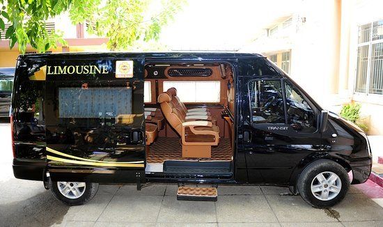 A black limousine van is parked on the side of the road.